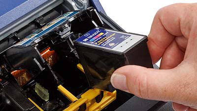 A person loading an ink cartridge.