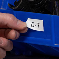 A person adjusts a removable bin label.