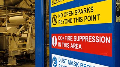 Warning labels on the door to a manufacturing facility.