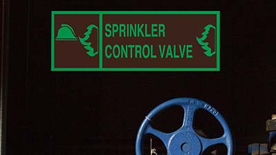A glow-in-the-dark label identifying a sprinkler control valve.