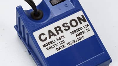 A Brady metallised matte-finish label on an electrical device identifying its voltage and amperage.