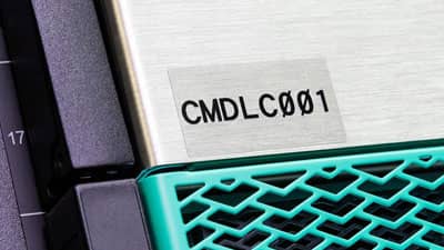 A Brady aggressive adhesive clear polyester label applied to the stainless steel case of a piece of electronic equipment.