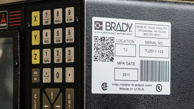 An equipment identification label with printed information, 1D and 2D barcodes.