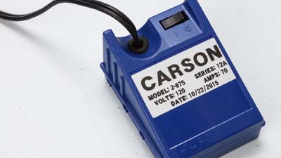 A Brady metallised matte-finish label on an electrical device identifying its voltage and amperage.