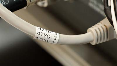 A Brady multi-purpose nylon label with the text 47YG 3 printed on it and applied to a Cat-5e ethernet cable.